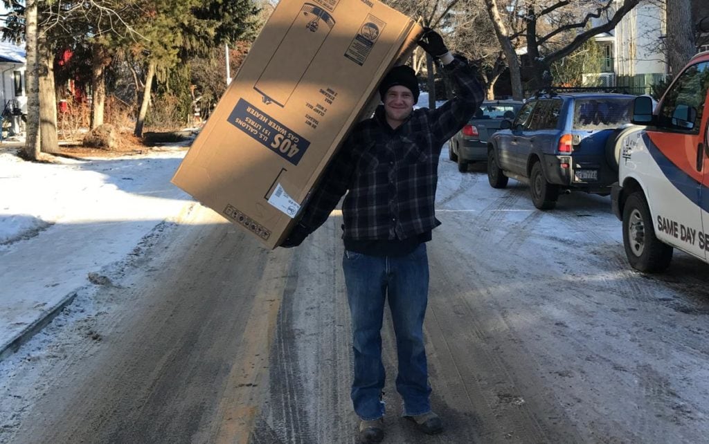 Edmonton man carrying a new amana furnace for replacement installation